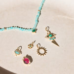 solid gold pieces displayed on hard surface including the Amazonite, Diamond & Moonstone Eye Necklace 9k Gold