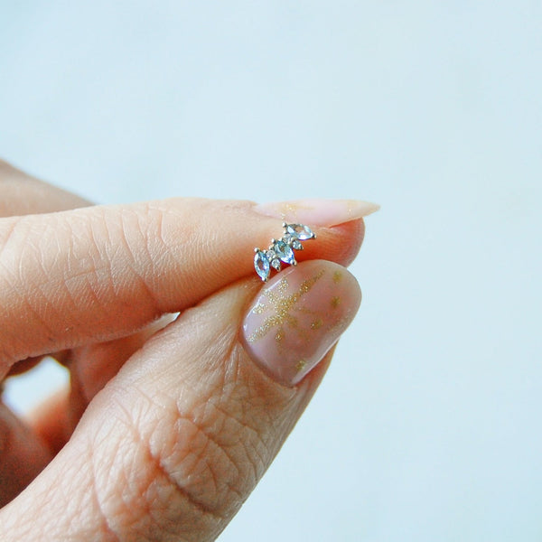 model hand holding the aquamarine & diamond flat back earring 14k gold