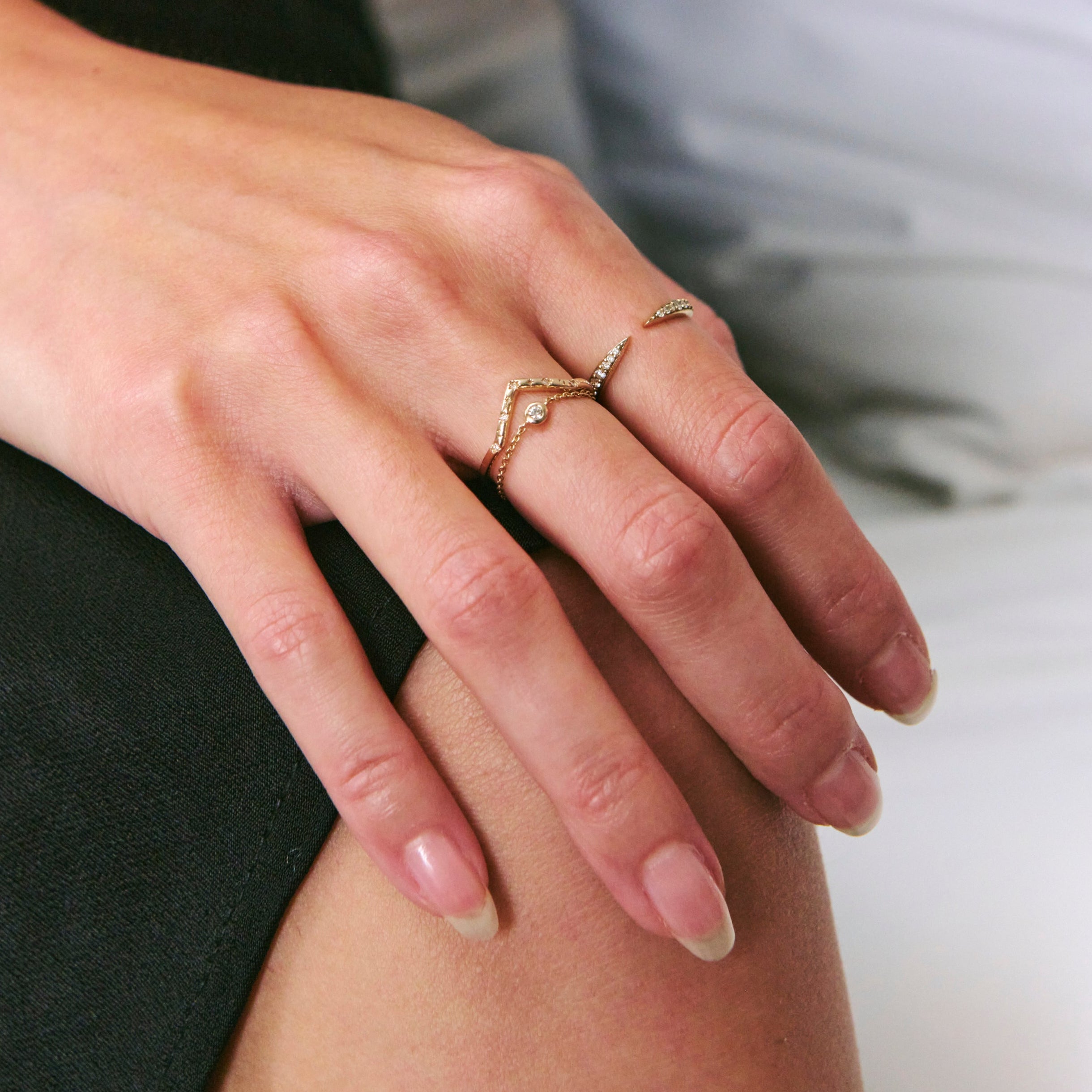 Close-up of a hand with multiple rings on a blurred background