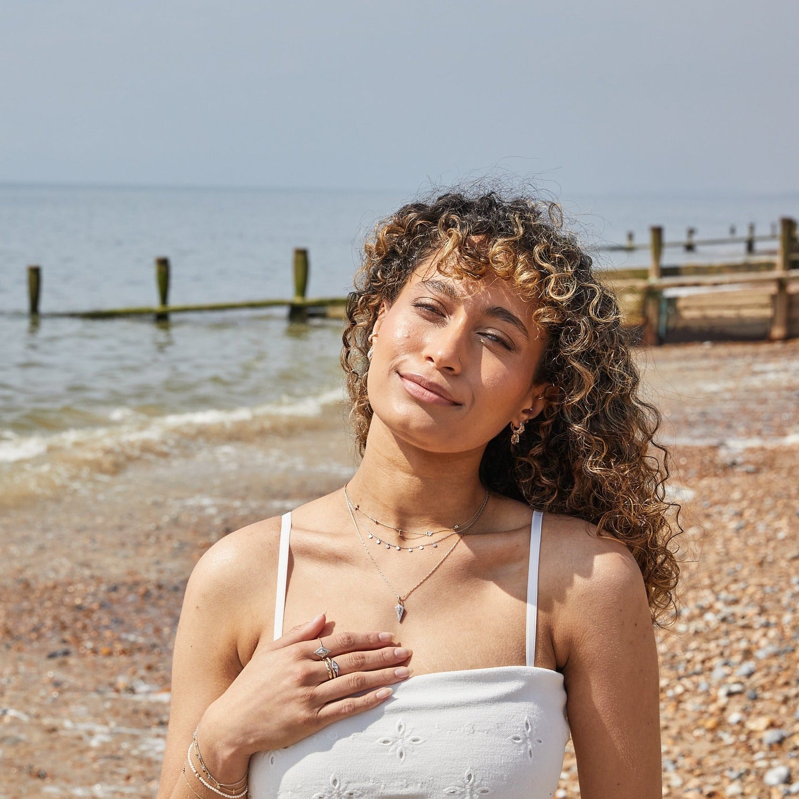 model wearing different necklaces layered including the Diamond Rhombus Necklace 9k Gold