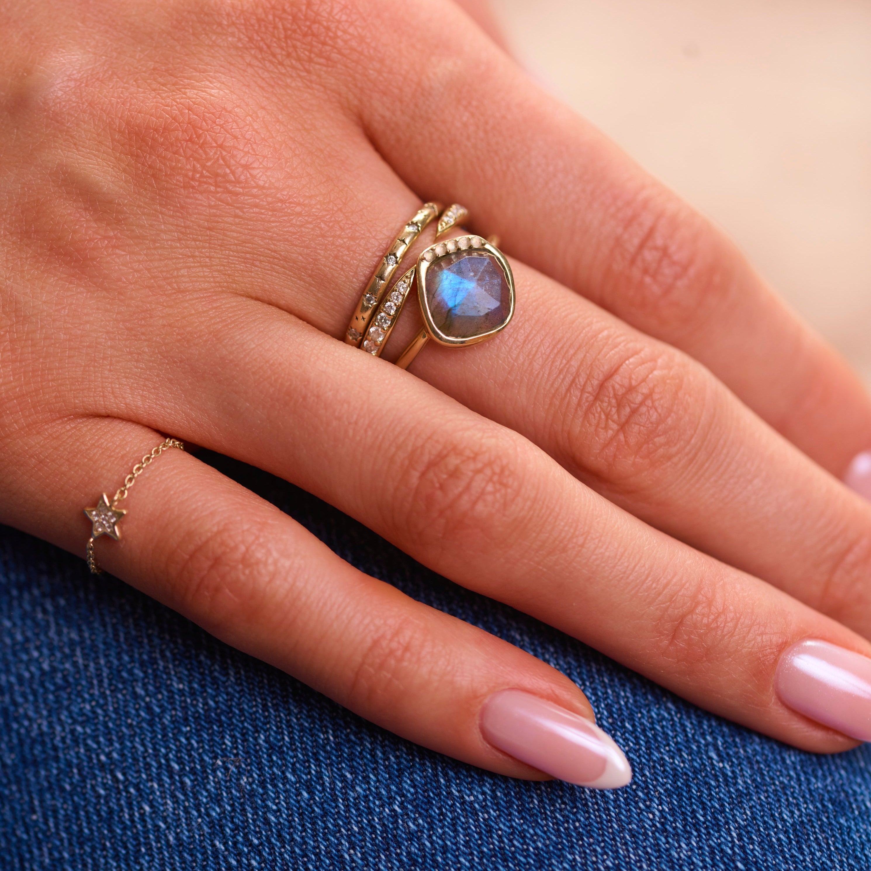 model hand wearing solid gold ring stack including the Diamond Star Chain Ring 9k Gold