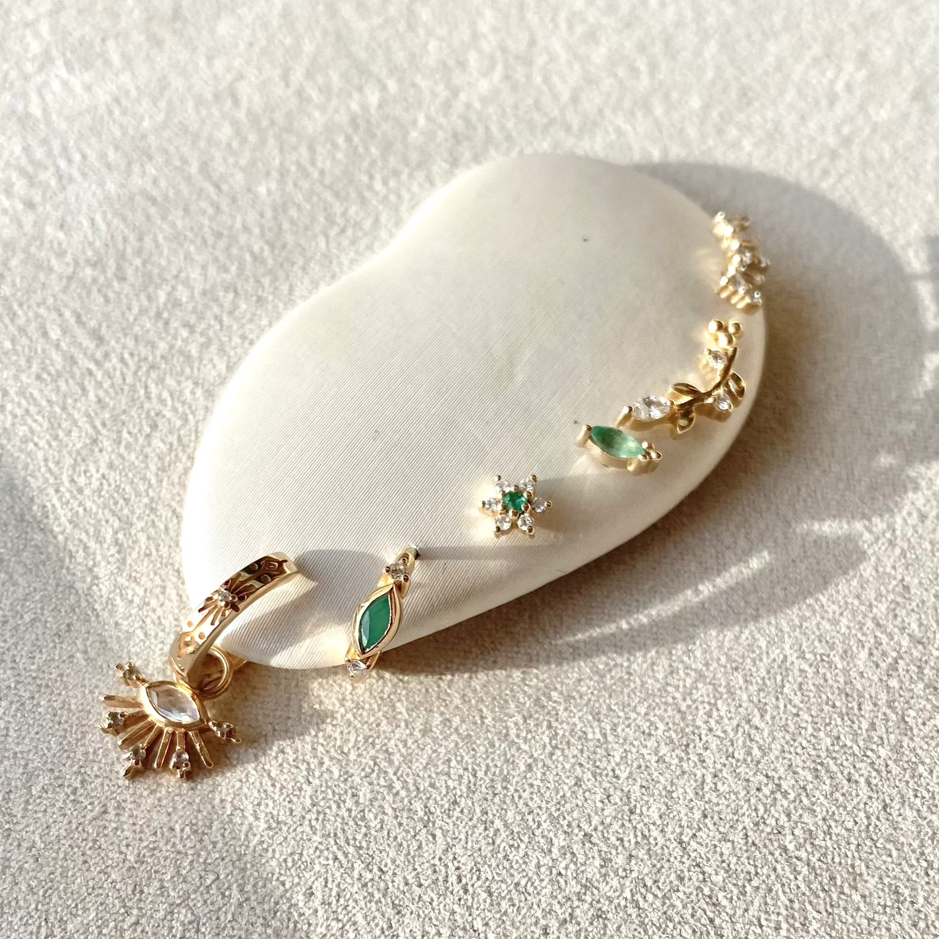 close up of solid gold ear stack including the Diamond & Emerald Flower Flat Back Earring 9k Gold