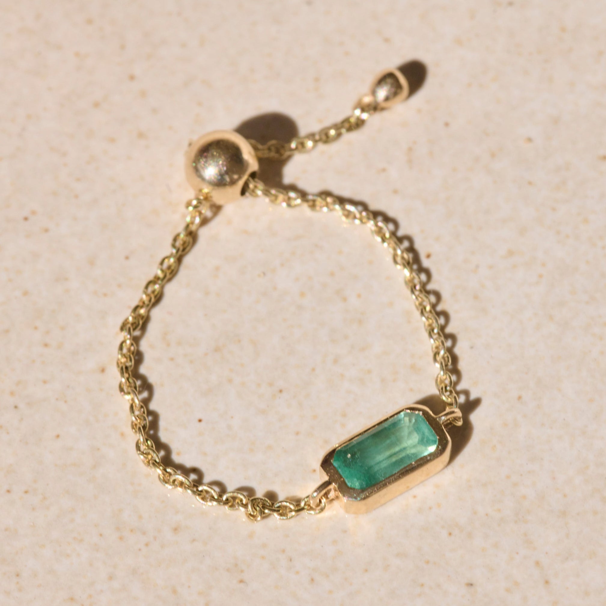 Emerald Chain Ring 9k Gold on hard surface