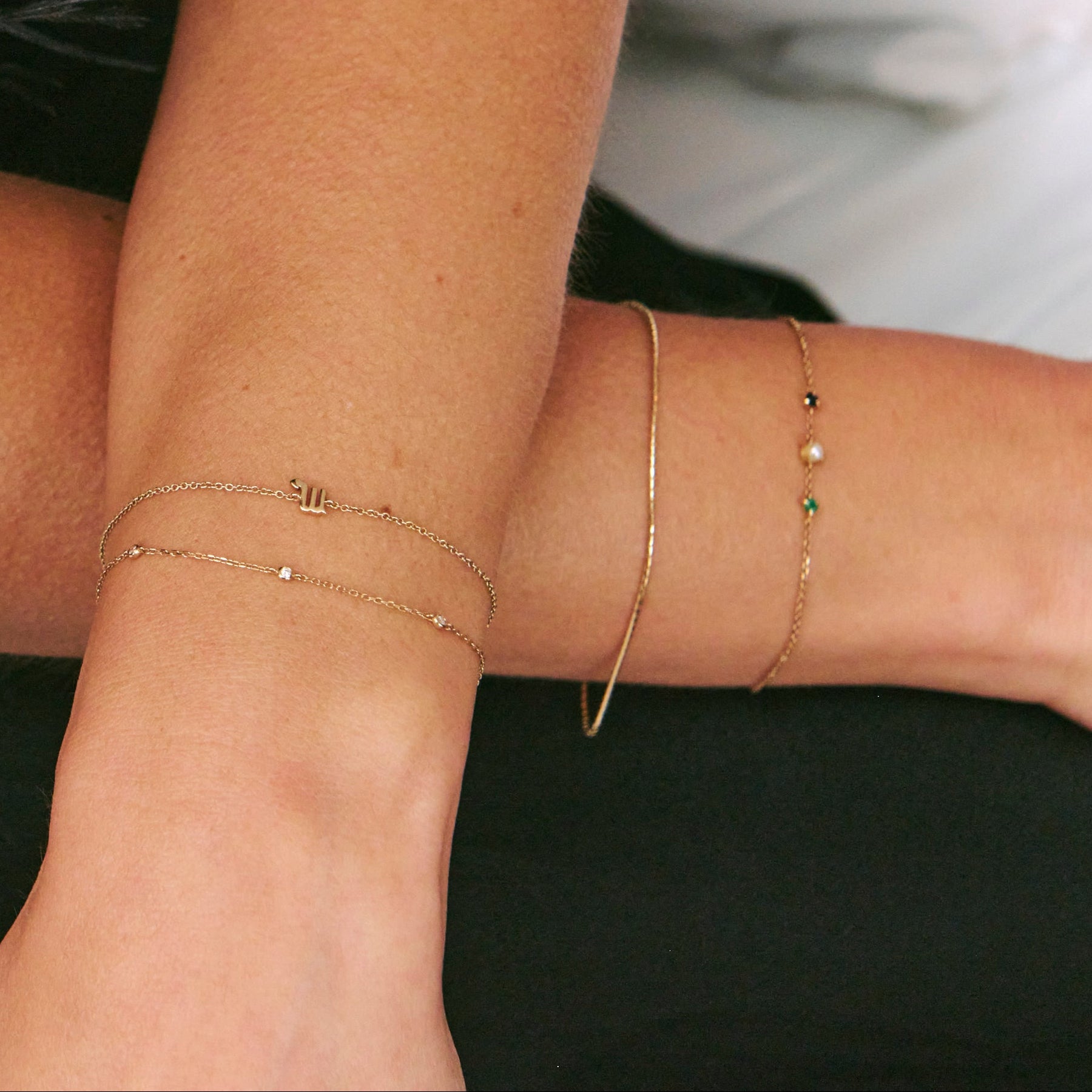 gold chain bracelets on model wearing black