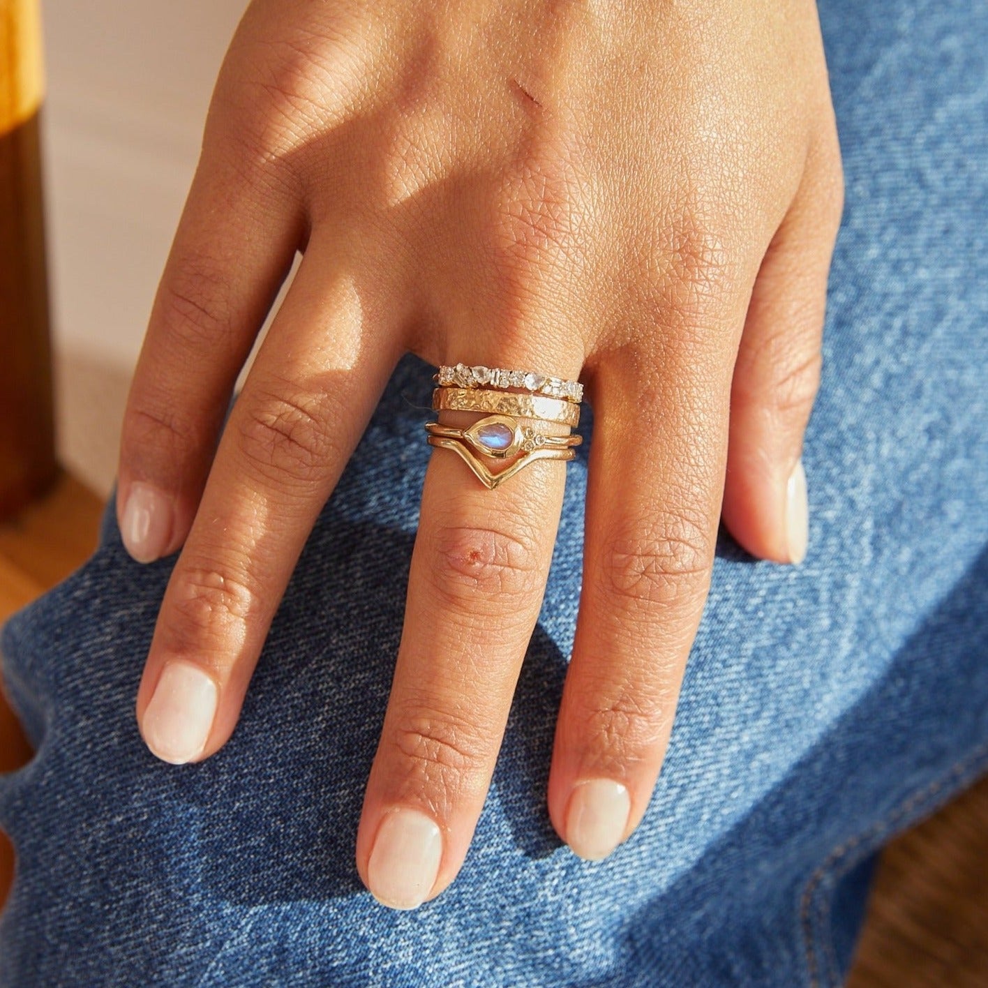model wearing solid gold rings including the Hammered Band Ring 9k Gold