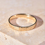 Hammered Band Ring 9k Gold on hard surface