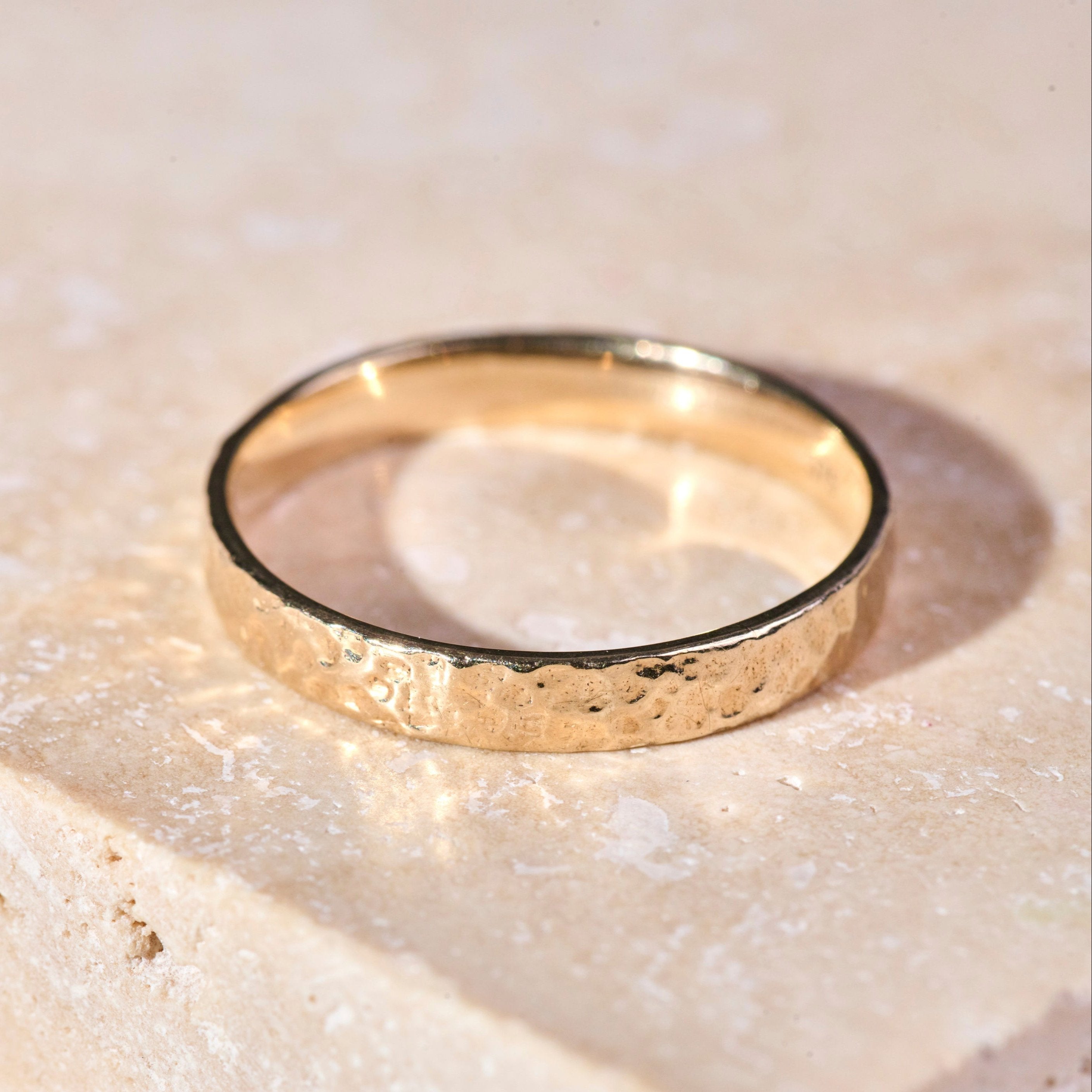 Hammered Band Ring 9k Gold on hard surface