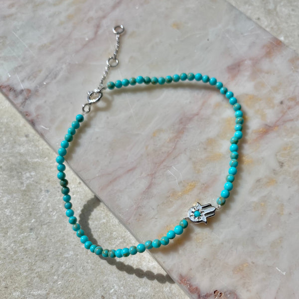 Hand of Fatima Turquoise Beaded Bracelet Sterling Silver on hard surface