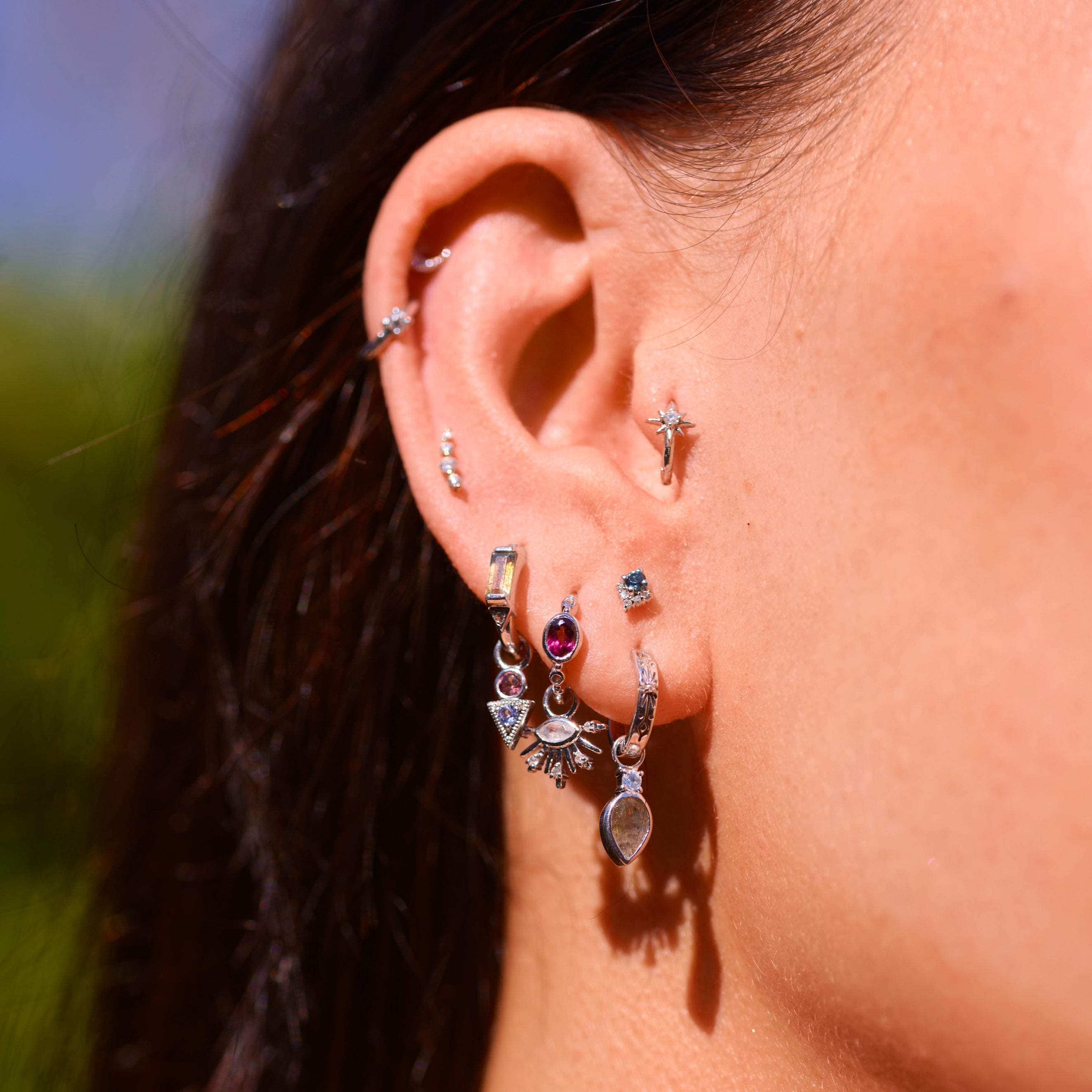 model wearing sterling silver and white gold ear stack including the Labradorite & White sapphire Huggie Hoop Earring Sterling Silver