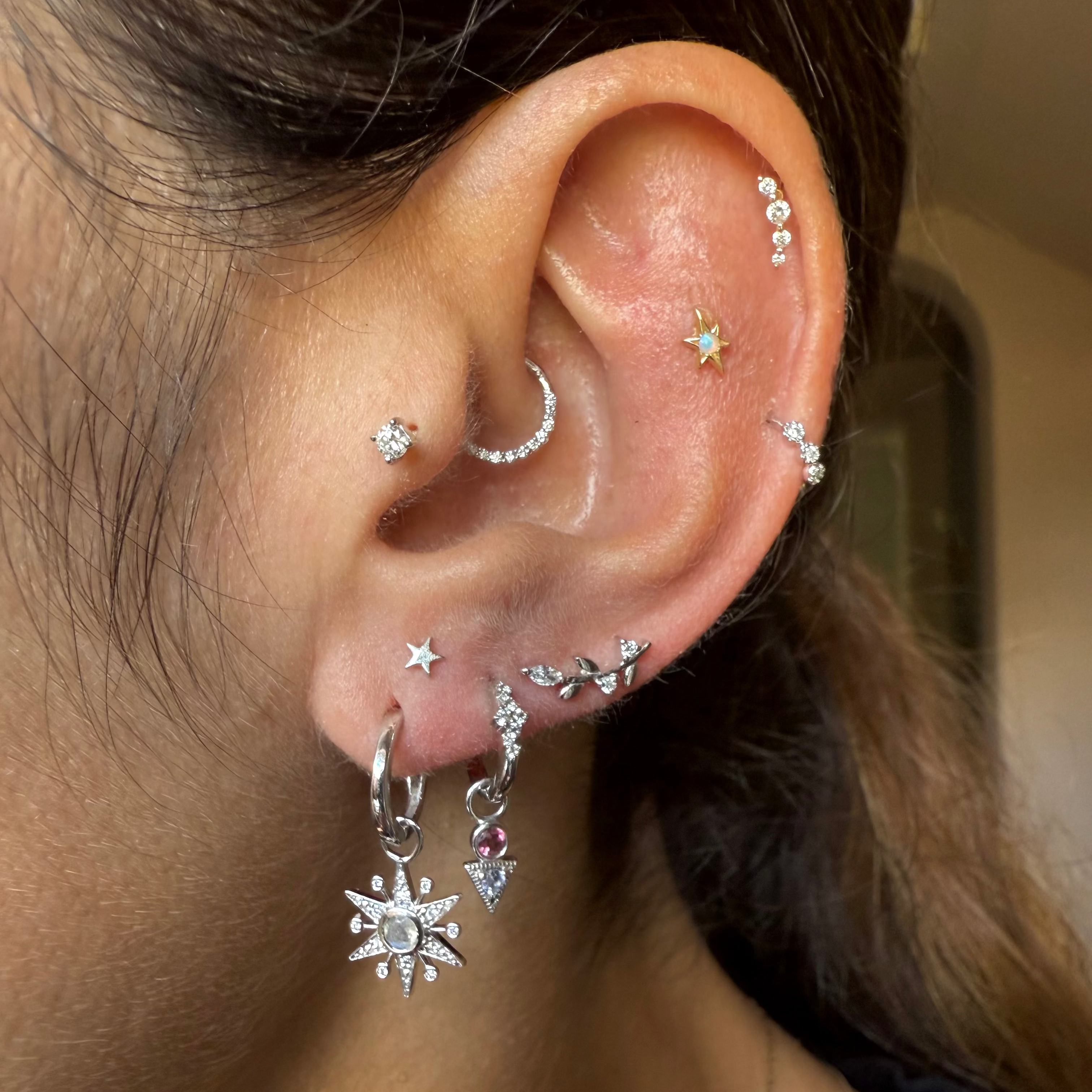 Close-up of an ear with multiple earrings and piercings.
