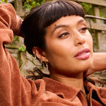 model wearing solid gold jewellery including the London Blue Topaz & Diamond Arrow Flat Back 9k Gold