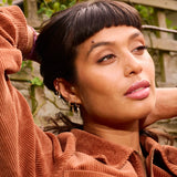 model wearing solid gold jewellery including the London Blue Topaz & Diamond Arrow Flat Back 9k Gold