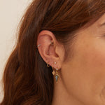 model wearing solid gold earrings including the Mini Diamond Beaded Huggie Hoop 9k Gold in mid helix