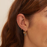 model wearing solid gold earrings including the Mini Diamond Beaded Huggie Hoop 9k Gold in mid helix