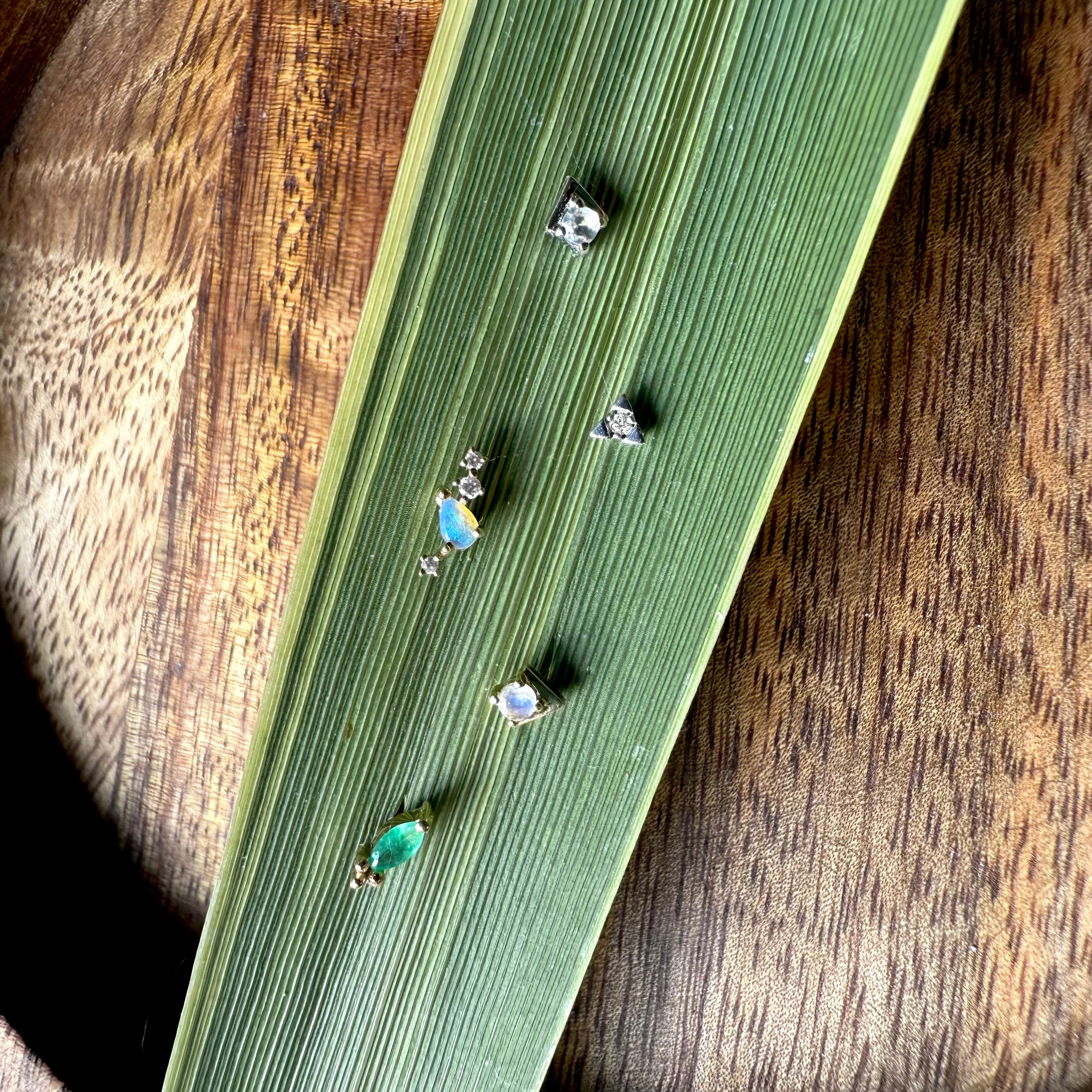 Small decorative stones on a green leaf with a wooden background