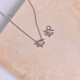 Moonstone & White Sapphire Sunburst Earring Charm and necklace in Sterling Silver on marble surface