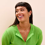 model wearing solid gold layered necklaces including the Moonstone & White Sapphire Sunburst Earring Charm 9k Gold