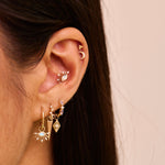 solid gold earring stack including the Moonstone & White Sapphire Sunburst Earring Charm 9k Gold