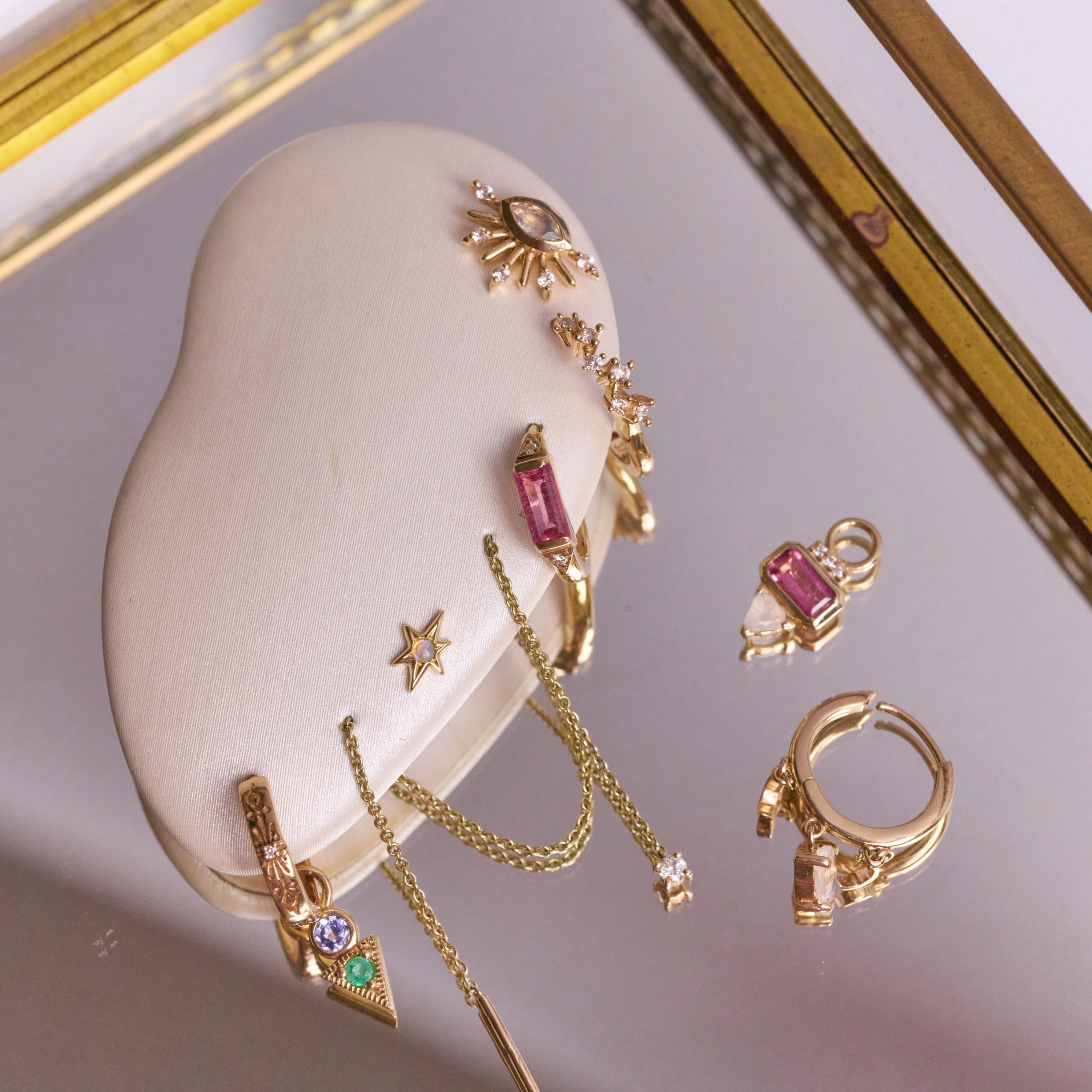solid gold earring pieces displayed including the Pink Tourmaline, Diamond & Moonstone Earring Charm 9k Gold