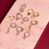 solid metal huggies and earring charms on hard surface including the Pink Tourmaline, Diamond & Moonstone Earring Charm 9k Gold