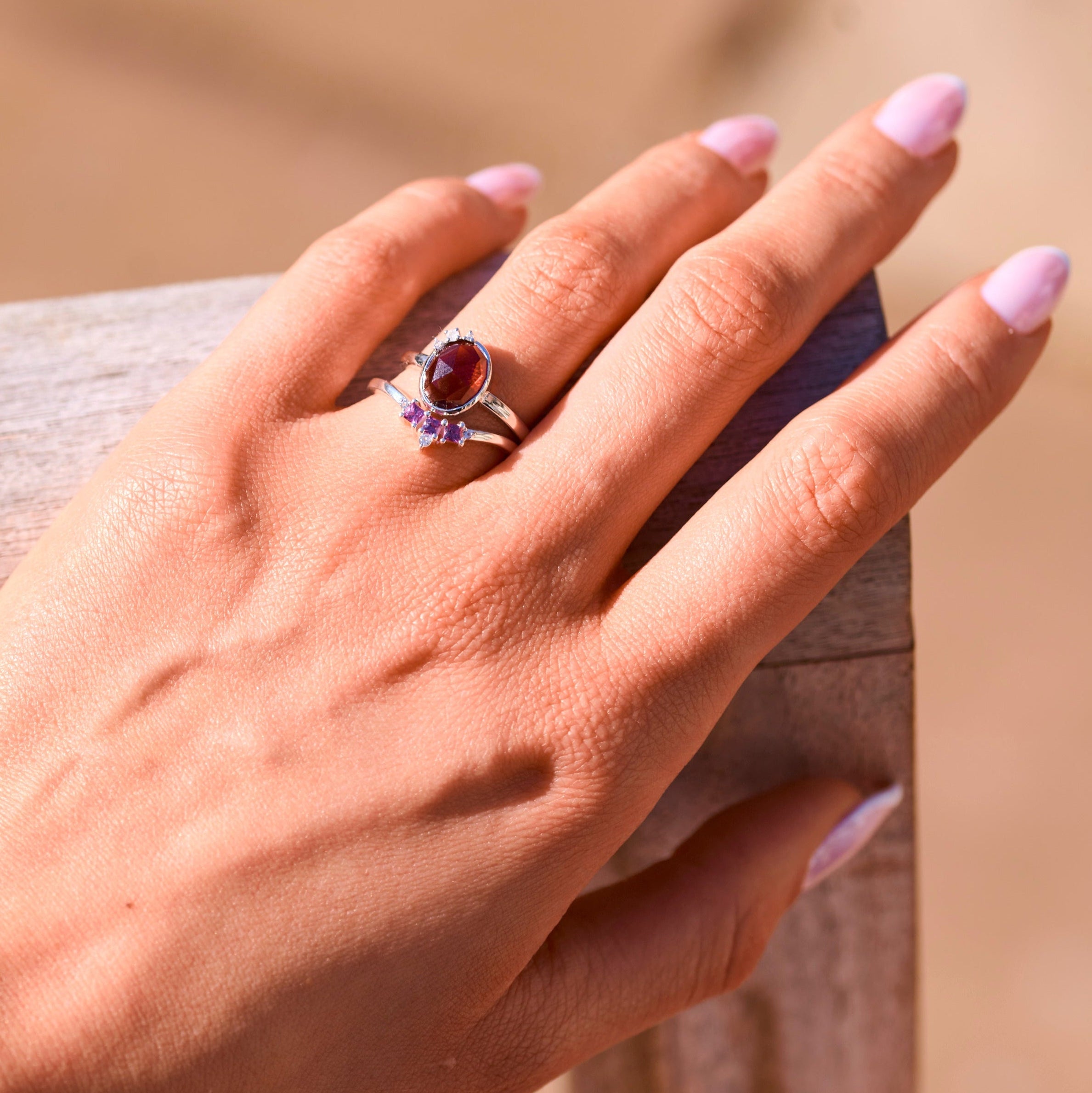 model hand wearing sterling silver rings including the Rhodolite Garnet, Moonstone & White Sapphire Ring Sterling Silver