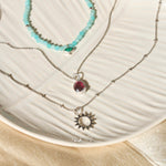 sterling silver necklaces displayed on porcelain dish including the Sunburst Silhouette Pendant Sterling Silver
