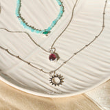 sterling silver necklaces displayed on porcelain dish including the Sunburst Silhouette Pendant Sterling Silver