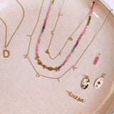 Solid 9k gold pieces on a porcelain plate including the Personalised Diamond Initial Necklace 9k Gold