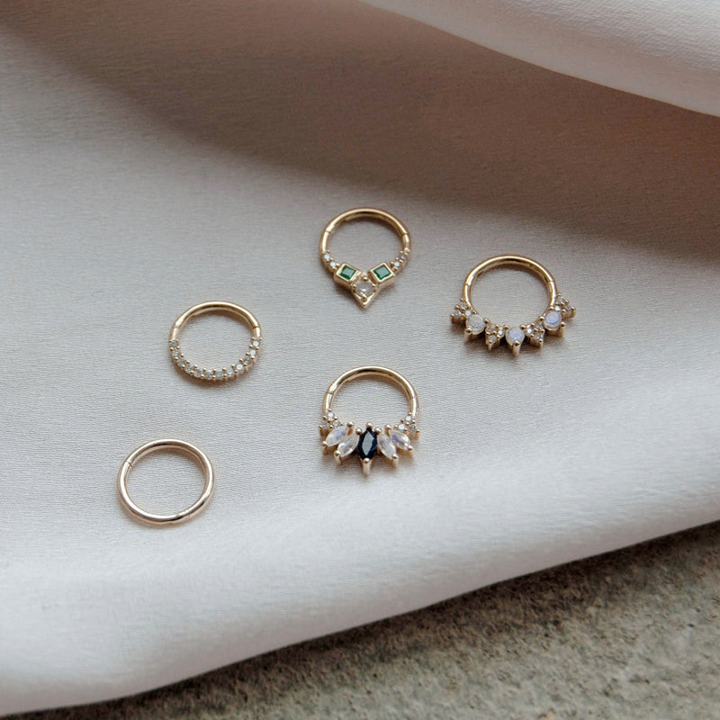 image of five daith earrings including diamond pave in 9k gold