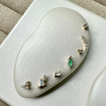 Set of earrings on a white cushion with a beige fabric background