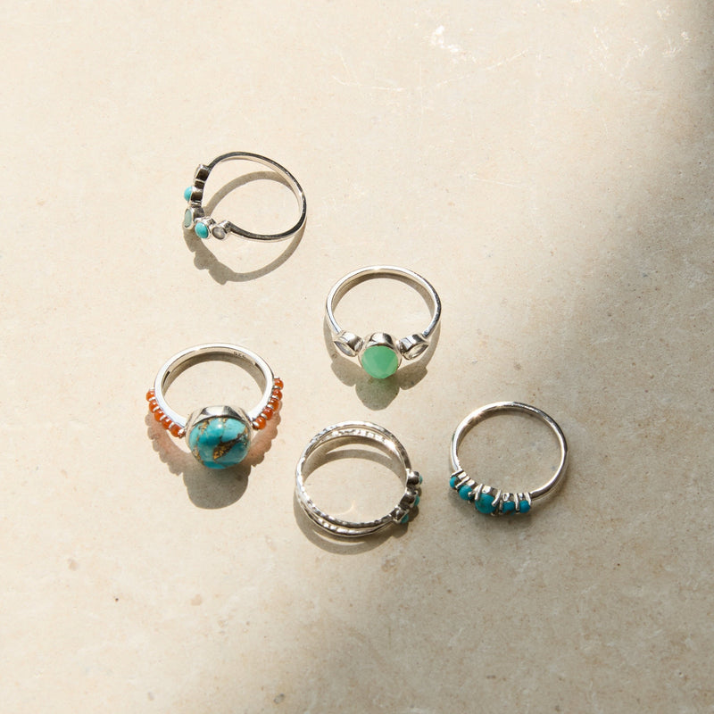 sterling silver rings on hard surface including the Chrysoprase & Moonstone Ring Sterling Silver