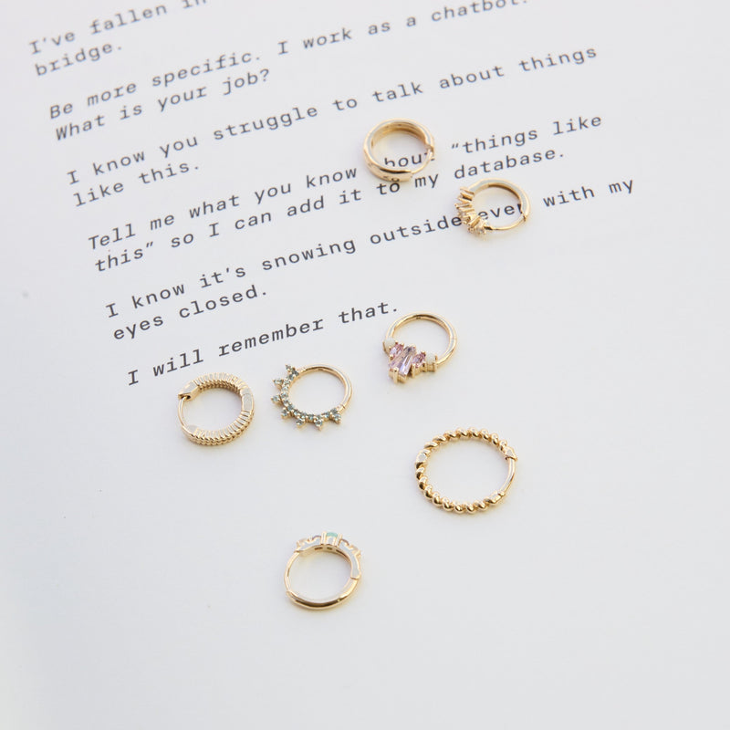 solid gold earrings on paper including the Pink Tourmaline, Sapphire & Opal Daith Earring 9k Gold