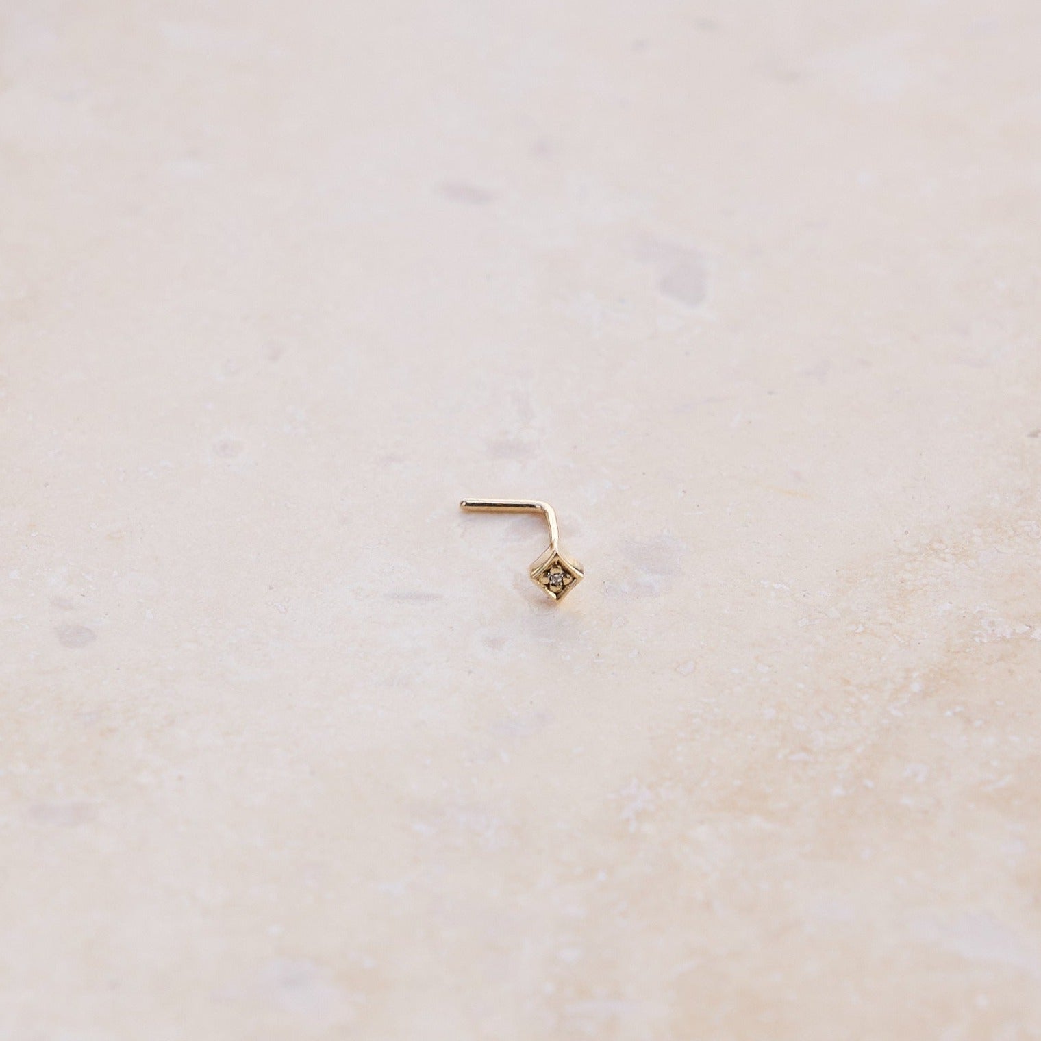 Engraved Diamond Nose Stud 9k Gold on hard surface