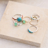 mix metals rings displayed on stone including the Turquoise Crossover Ring Silver 