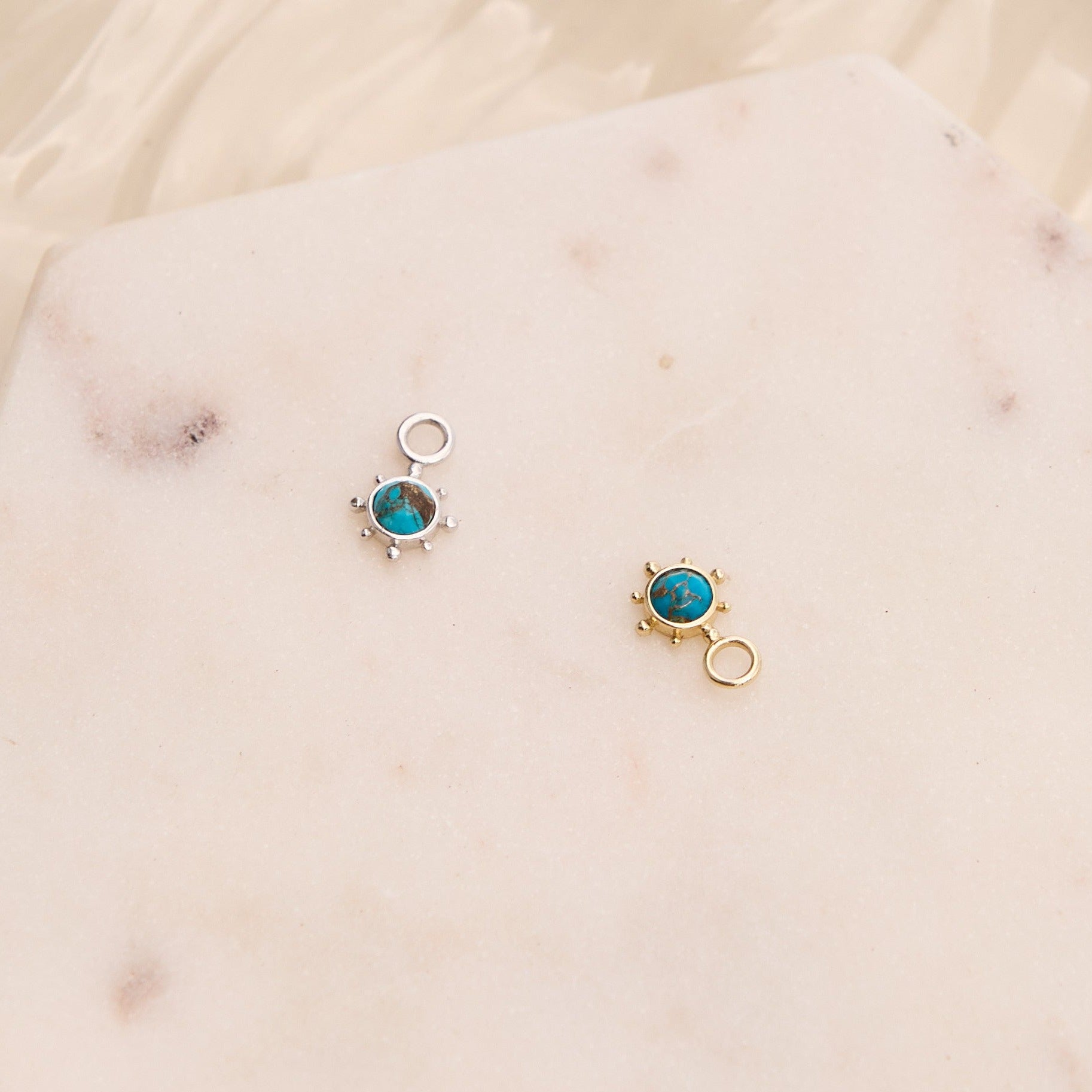 Copper Turquoise Earring Charm Sterling Silver and solid gold on hard surface