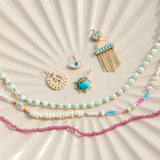 solid gold pendants and beaded pieces on porcelain dish including the Aztec Turquoise Pendant 9k Gold