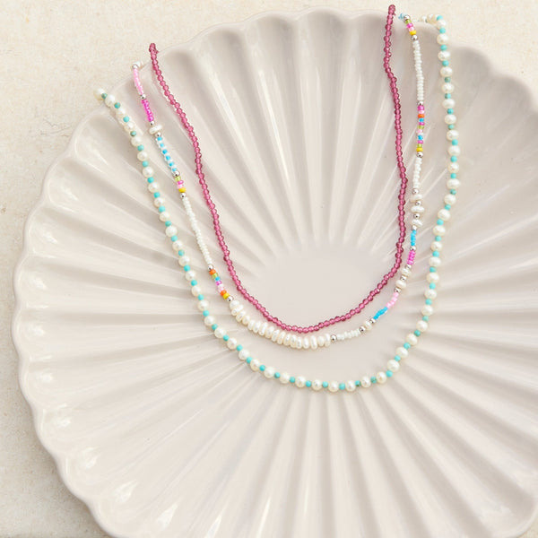 beaded necklaces displayed on textured porcelain dish including the Pearl & Seed Bead Necklace Sterling Silver