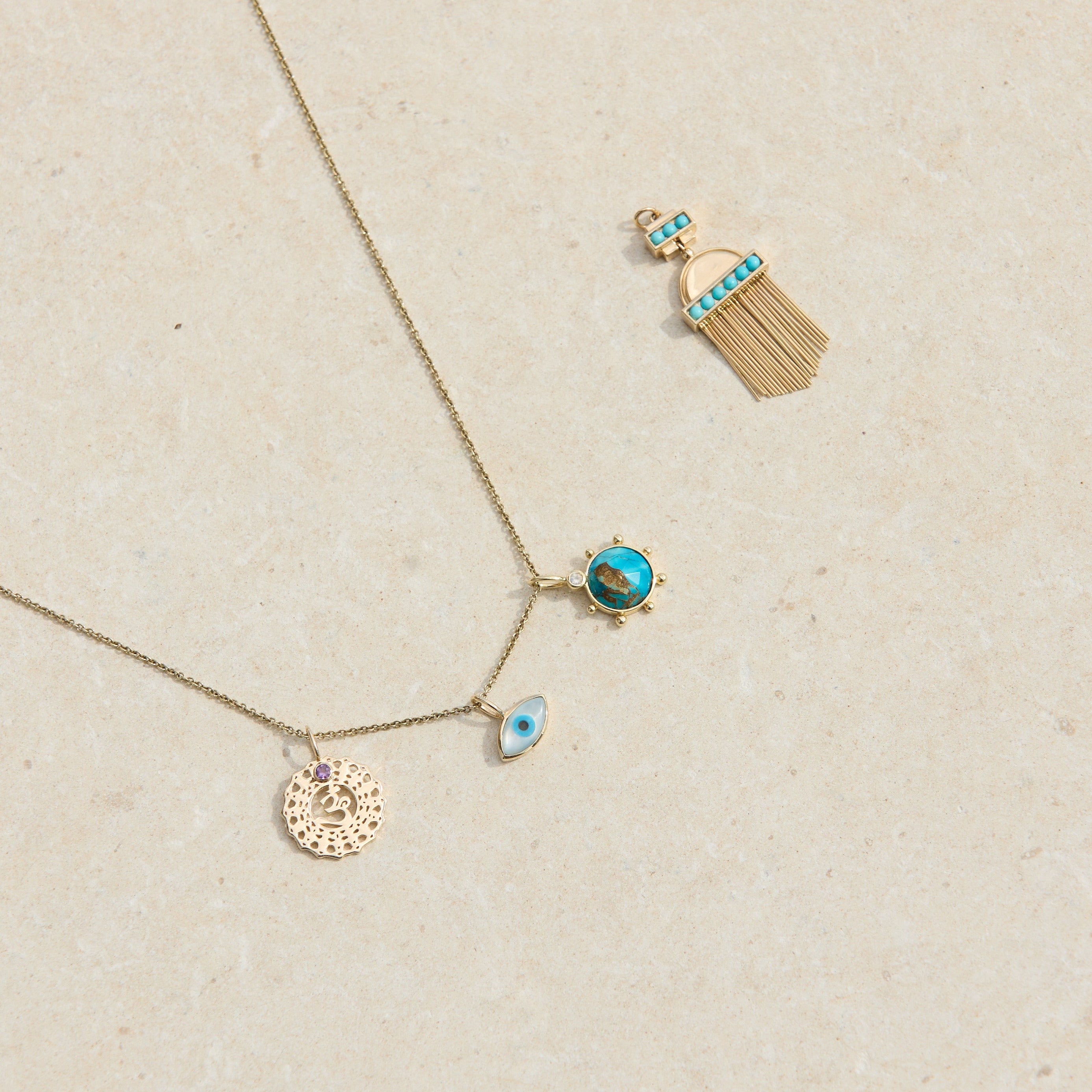 solid gold pendants on hard surface including the Aztec Turquoise Pendant 9k Gold