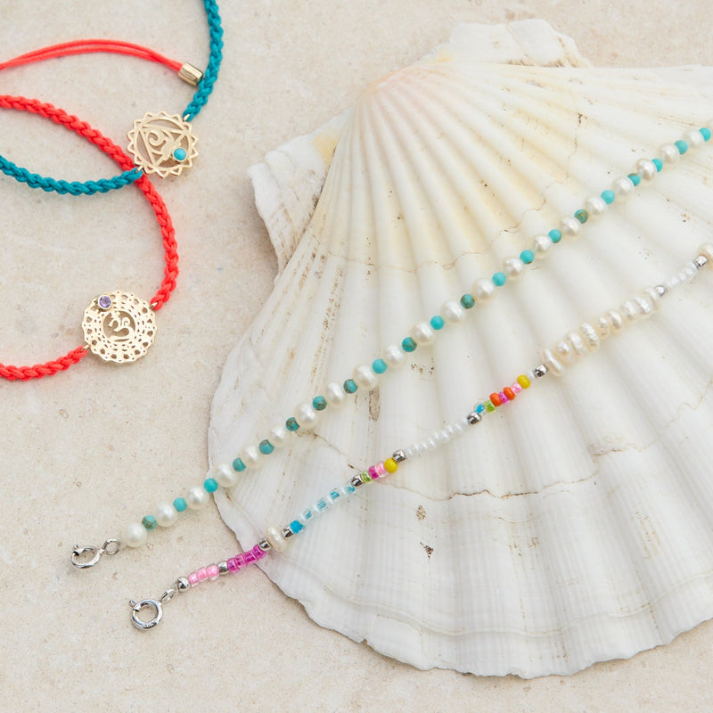 colourful jewellery pieces on stone and shell including the Pearl & Turquoise Necklace Sterling Silver 