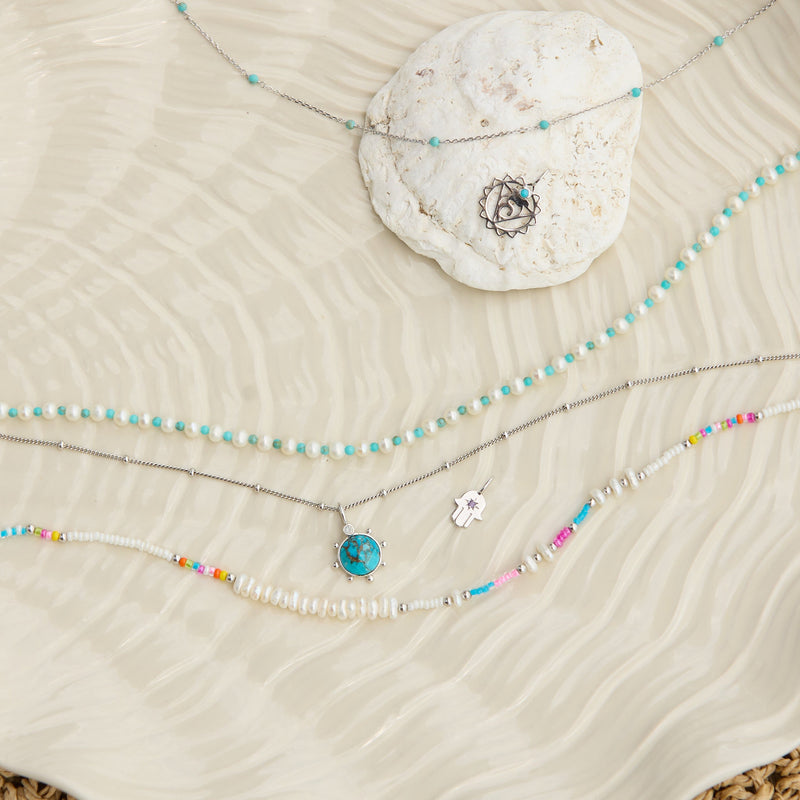 sterling silver jewellery pieces displayed on textured surface including the Copper Turquoise & Moonstone Pendant Sterling Silver