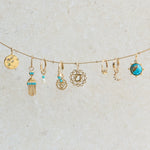 solid gold pendants and earrings hanging from stationed bead chain including the Copper Turquoise & Moonstone Pendant 9k Gold 