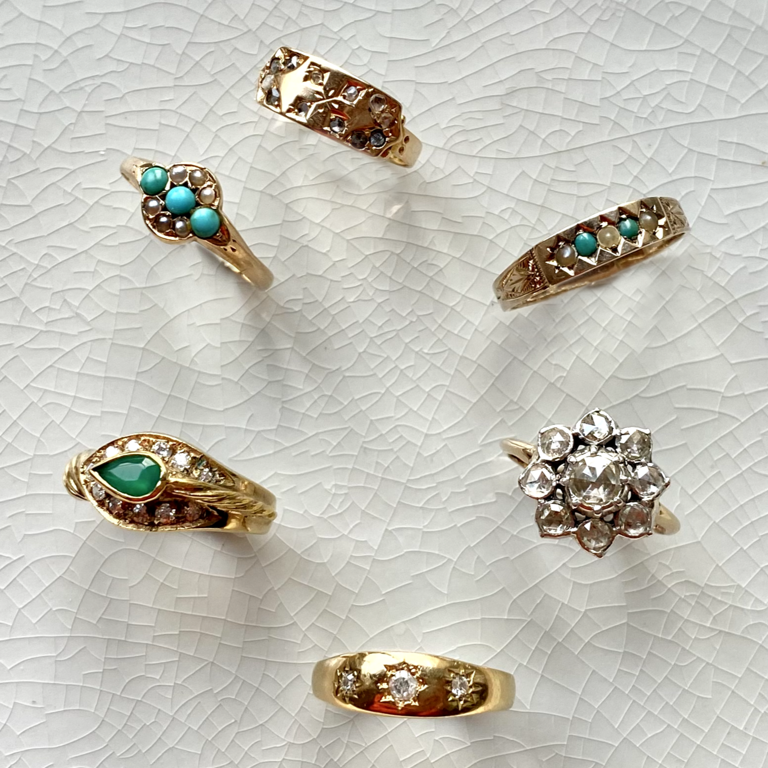 solid gold vintage rings displayed on tile, including the 15 kt Gold Salt & Pepper Diamond Signet Vintage Ring

