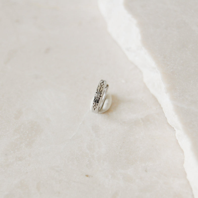 White Sapphire Starburst Huggie Hoop Earring Sterling Silver on marble surface