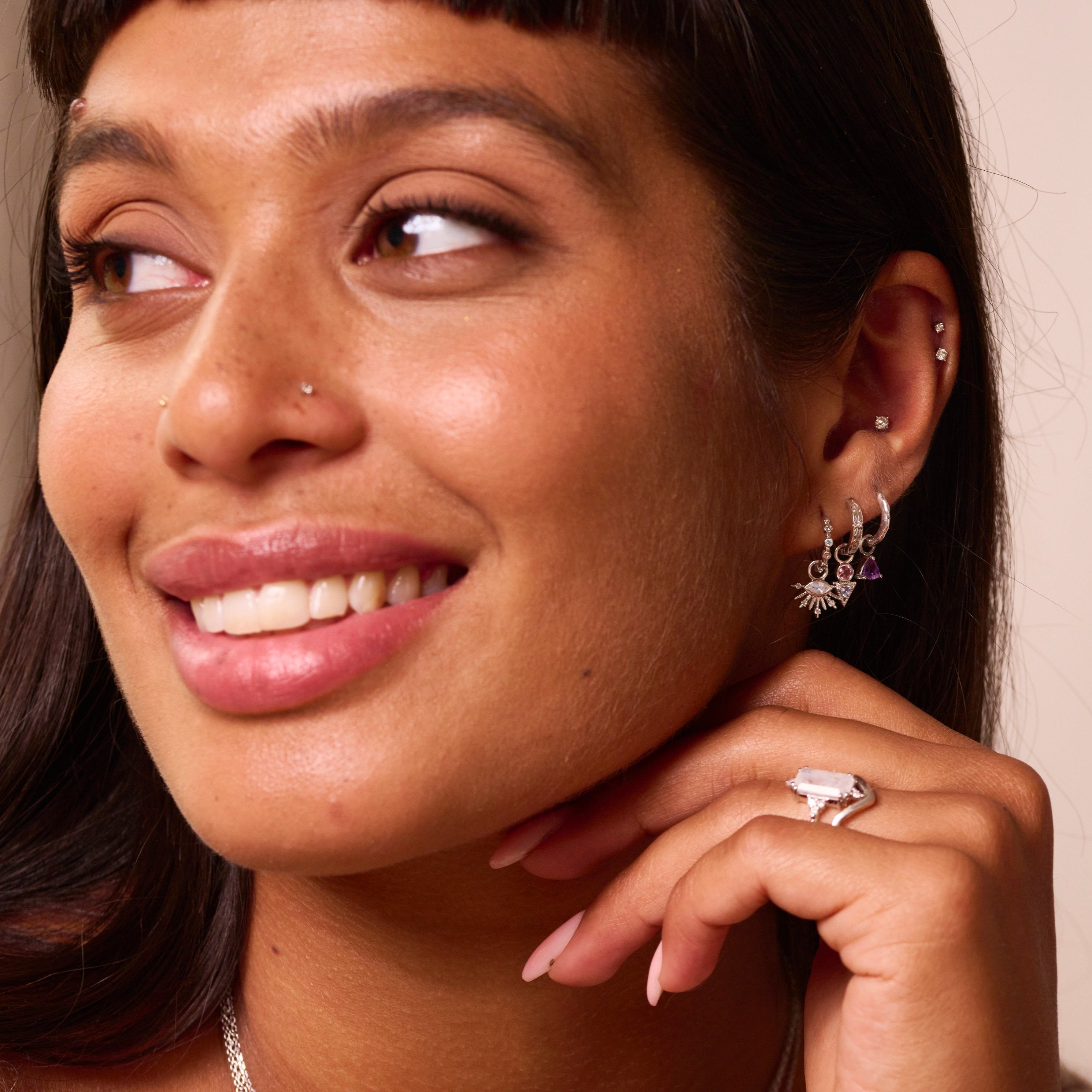 model wearing sterling silver ear stack including the Amethyst Trillion Earring Charm Sterling Silver