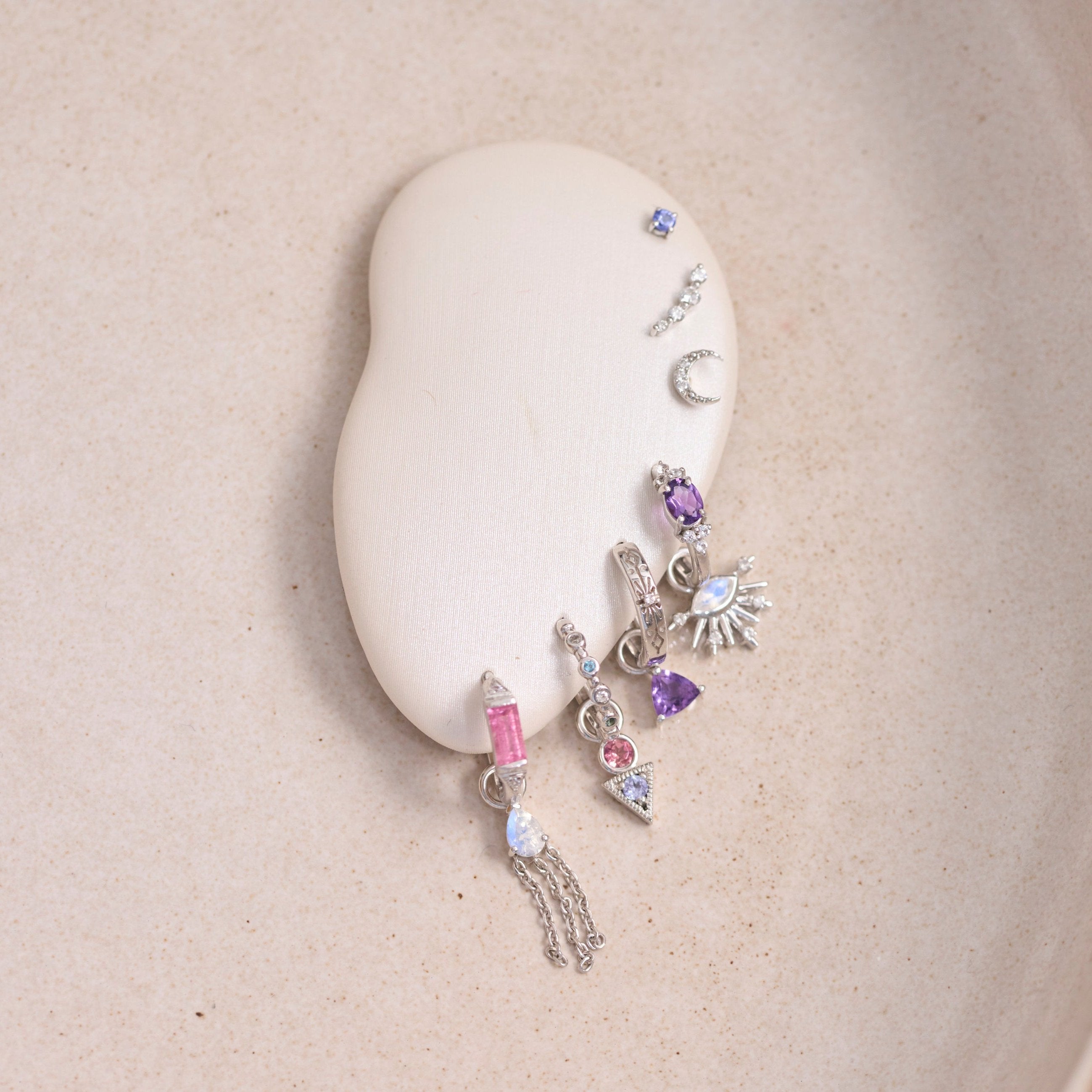 ear display showing sterling silver huggie hoops and earring charms including the Amethyst & White sapphire Huggie Hoop Earring Sterling Silver
