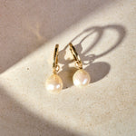 Baroque Pearl Hoop Earrings 9k Gold on marble surface