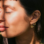 model wearing solid gold ear stack including the Beaded Flower Earring Charm 9k Gold