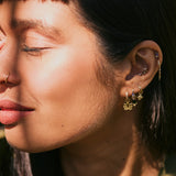 model wearing solid gold ear stack including the Beaded Flower Earring Charm 9k Gold