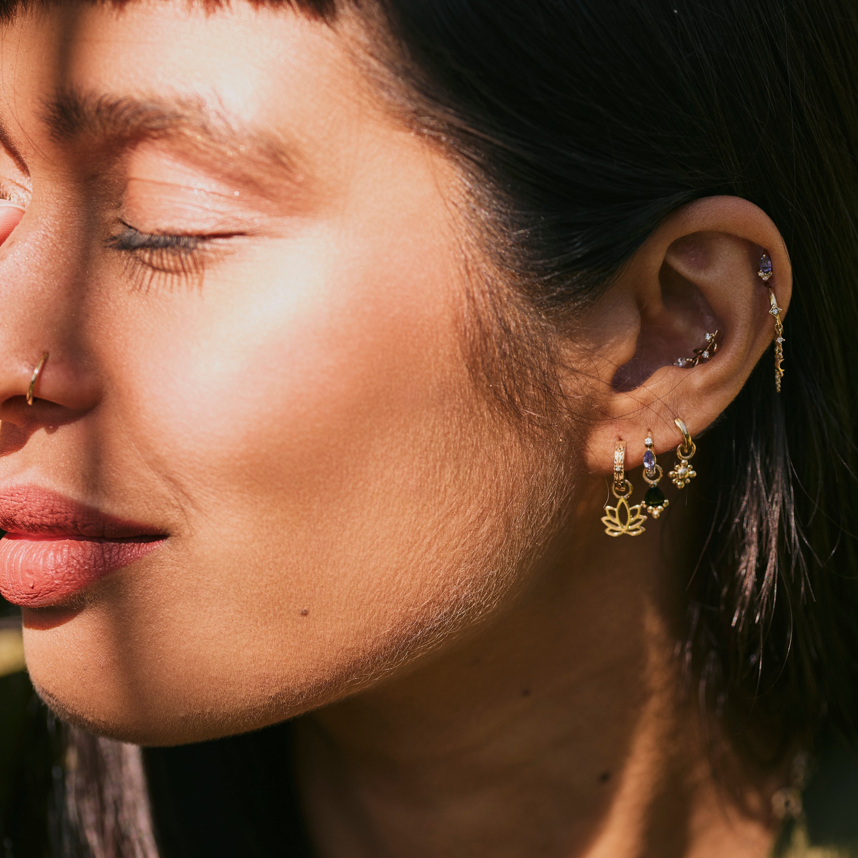 model wearing solid gold ear stack including the Beaded Flower Earring Charm 9k Gold