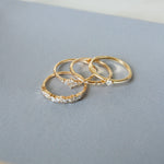 solid gold and diamond rings on smooth surface including the Celestial Diamond Band Ring 9k White Gold